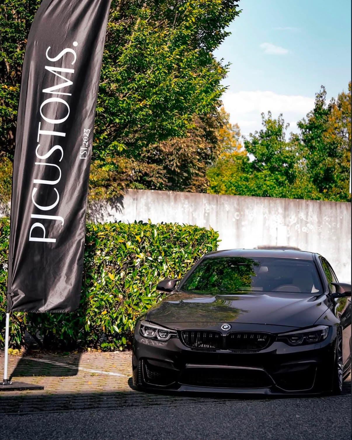 Schwarzer BMW M4 vor der PJ Customs Beachflag